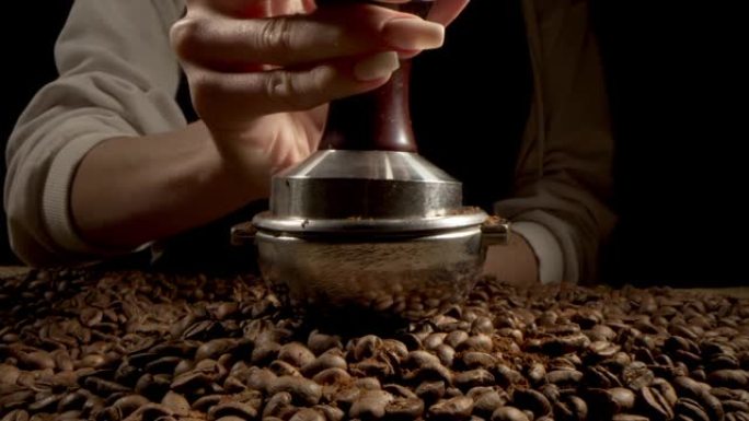 从咖啡机中填充烘焙咖啡的研磨机的特写慢动作。在高速电影摄影机上拍摄