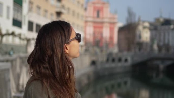 一名年轻女子戴着墨镜欣赏旧城美景的特写镜头