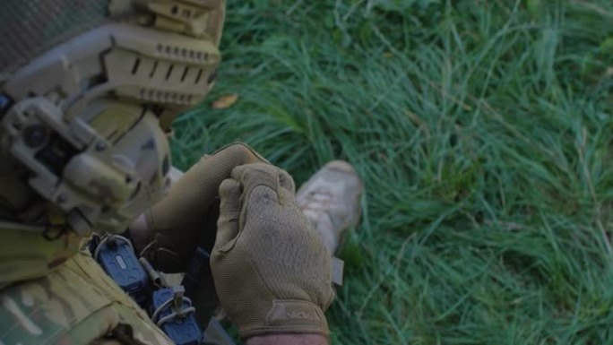 身着迷彩制服的士兵为军事演习或战斗做准备。近距离的军人的手将子弹装到机枪上。乌克兰军队，战争
