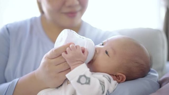 母亲用婴儿奶瓶喂养婴儿