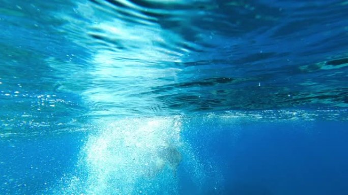 人在鳍水下游泳并浮出水面