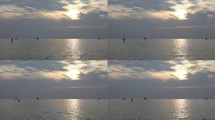 Distant stand up paddle-boarders ply tranquil seas