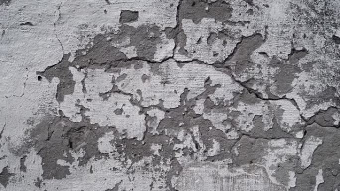 灰色旧裂缝墙为背景。工业建筑中带有裂缝的垃圾混凝土水泥墙
