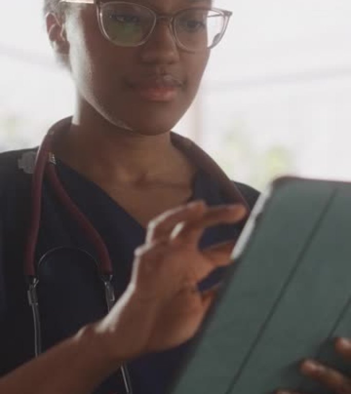 垂直屏幕: 年轻的女医生在她的办公室在平板电脑上工作。美丽的非洲医疗保健专业人员，负责测试结果，患者