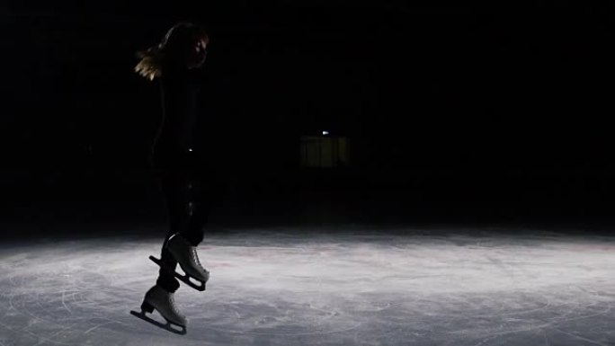 穿着黑色西装的溜冰者，轮廓优美，突然加速并停止。从溜冰鞋上飞出的冰块以三重转弯进行跳跃。绕其轴旋转。