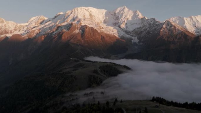 空中无人机拍摄了日落时分云反转的雪山线