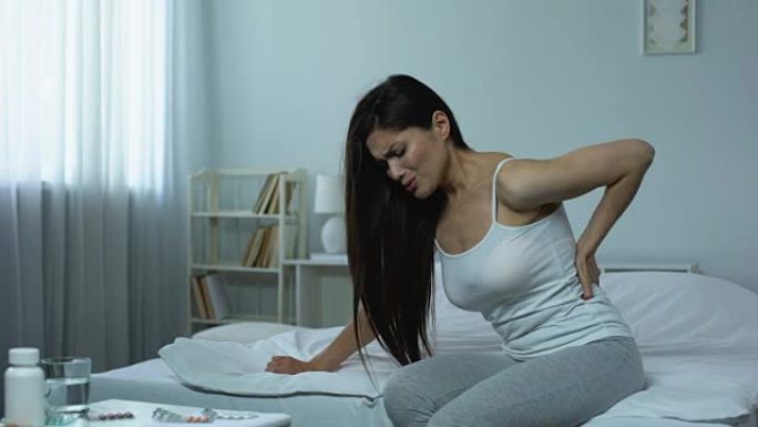 女性躺在床上遭受严重的背痛，受伤的后果