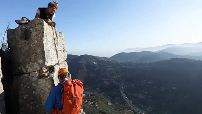 登山者登上垂直岩石顶峰