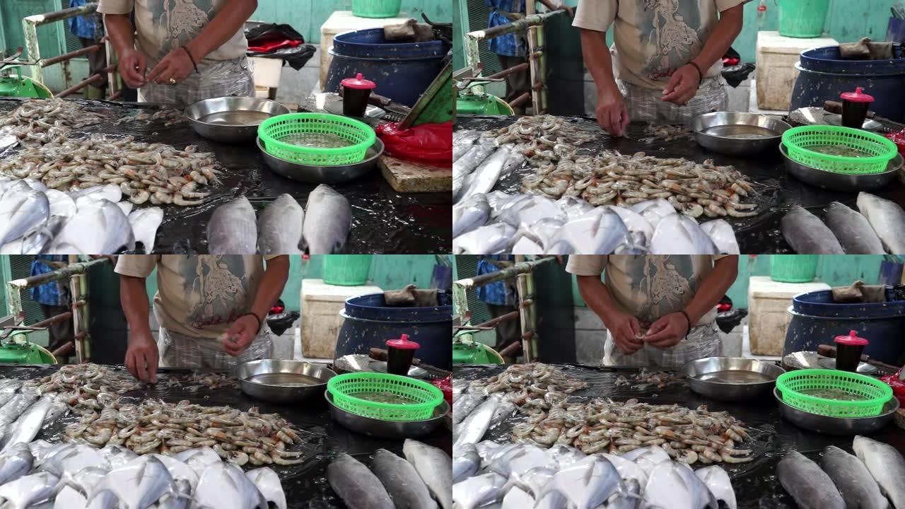 一名男子在中国鱼市清洗虾