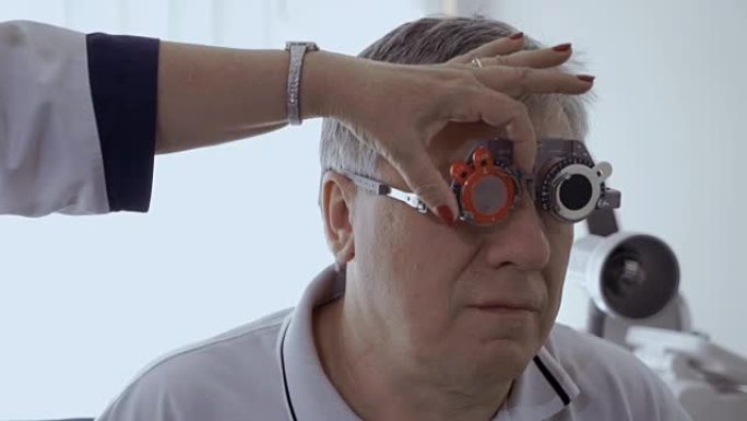 医生用光学试验框架检查男人的视线