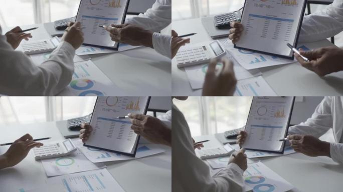 亚洲商人在统计分析计划会议上集思广益，团队负责人指出图表并记录财务成功统计数据。4k 30p视频。