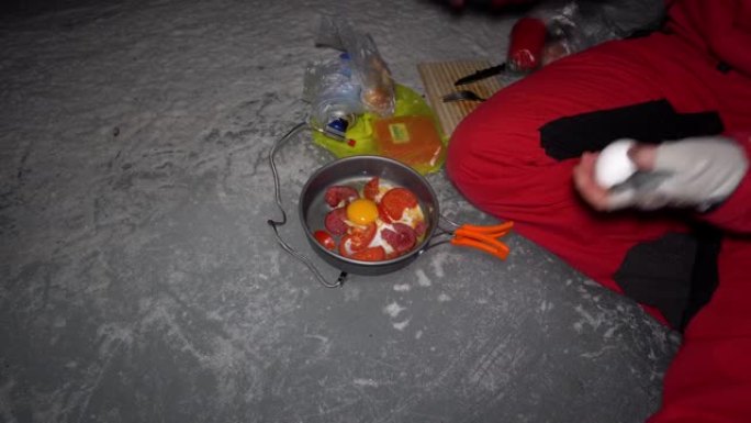 一个人在冰洞里用煤气做饭。