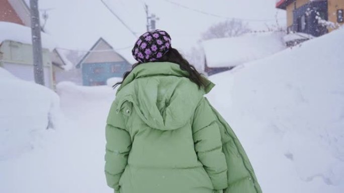 下雪时走路的女人下雪天气前进回家
