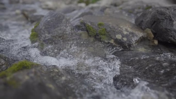 在岩石山坡上流水的详细镜头