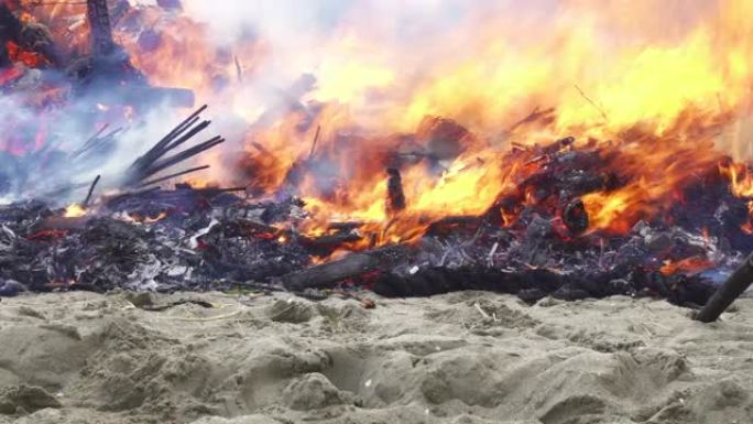 沙滩上的篝火。剧烈燃烧的木头碎片。东多亚基