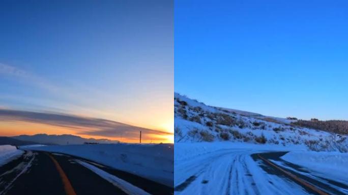 黄昏时在雪山路上驶向日落