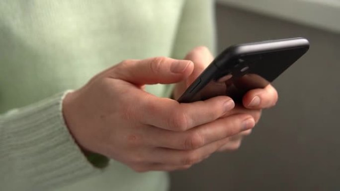 女人用iPhone 11智能手机按手指，阅读互联网，打字