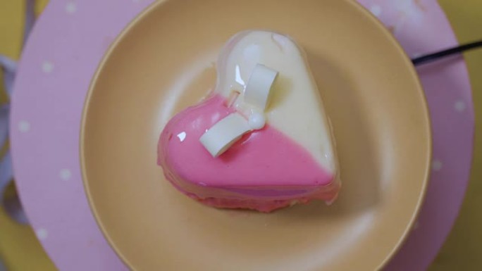 白色和粉红色釉面的心甜点在桌子上转来转去