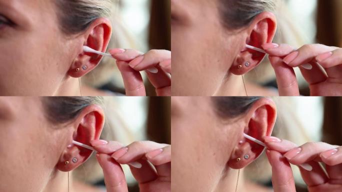 妇女清洁耳朵和使用Q-tip的特写镜头