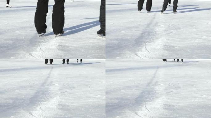 两个人穿着黑色花样溜冰鞋的男人或女人在溜冰场上离开相机