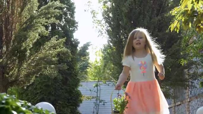 穿着粉红色连衣裙的可爱小女孩在花园里的绿树间奔跑
