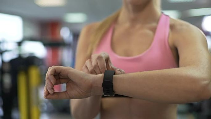 健身女性在健身房开始锻炼前清除健康手镯的指标