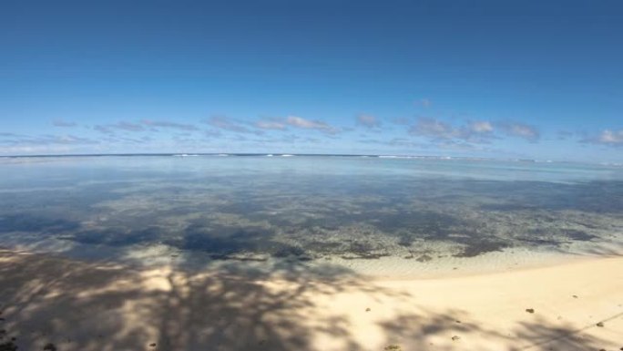 超广角平视平静的绿松石蓝色泻湖从柔软的粉末沙滩到太平洋地平线，深蓝色的天空将椰子树的阴影投射到地面上