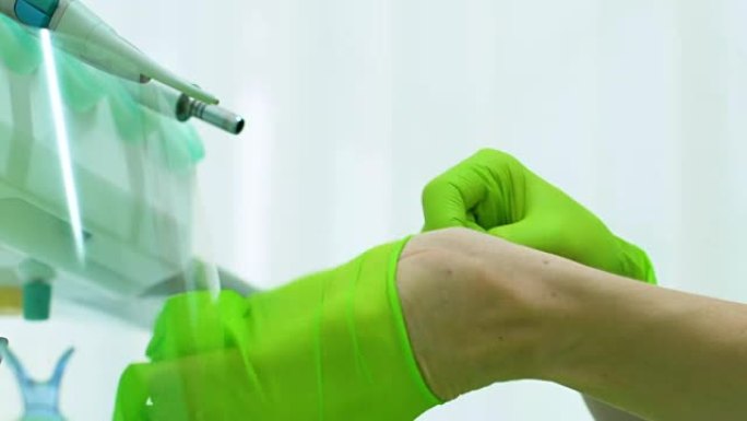 牙科助理戴上乳胶手套在手，准备帮助医生