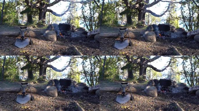 铁锹和铸铁锅在阿根廷巴塔哥尼亚los alerces国家公园的一个湖边的露天篝火上做饭。