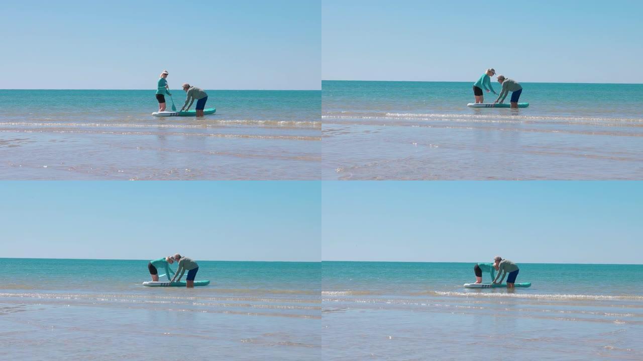 成熟的夫妇准备在海滩上划桨