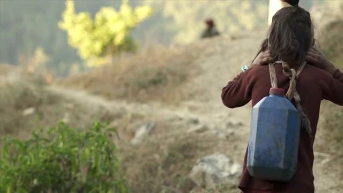 年轻的尼泊尔女孩拿着带头带的水壶