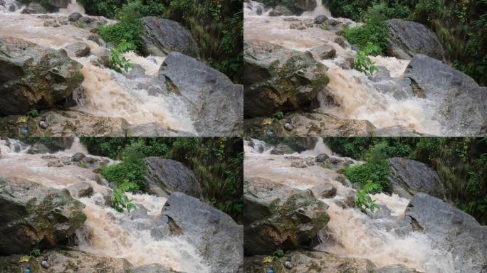 台风下雨时，水在尼泊尔山丘上的瀑布岩石上肆虐。