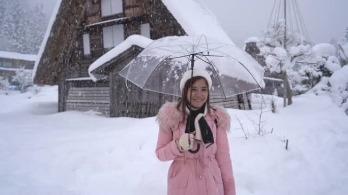 美丽的女人游客在冬天享受着白川村的旅行