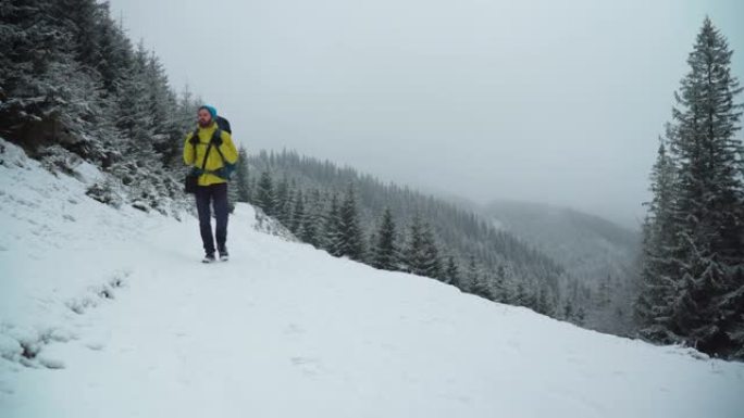 男性徒步旅行者在冬天的雪山中攀登