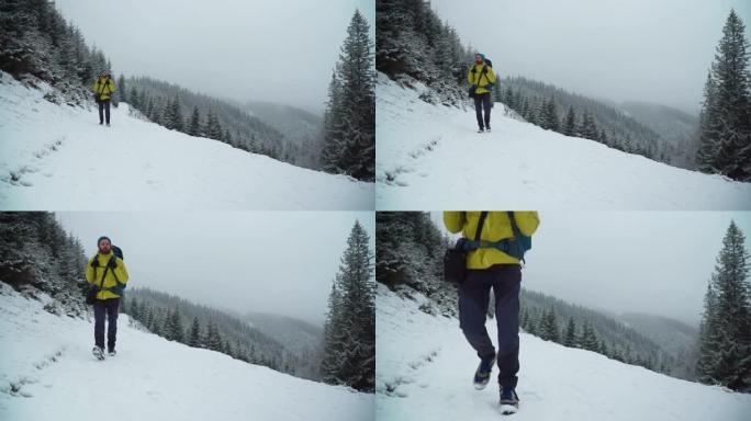 男性徒步旅行者在冬天的雪山中攀登