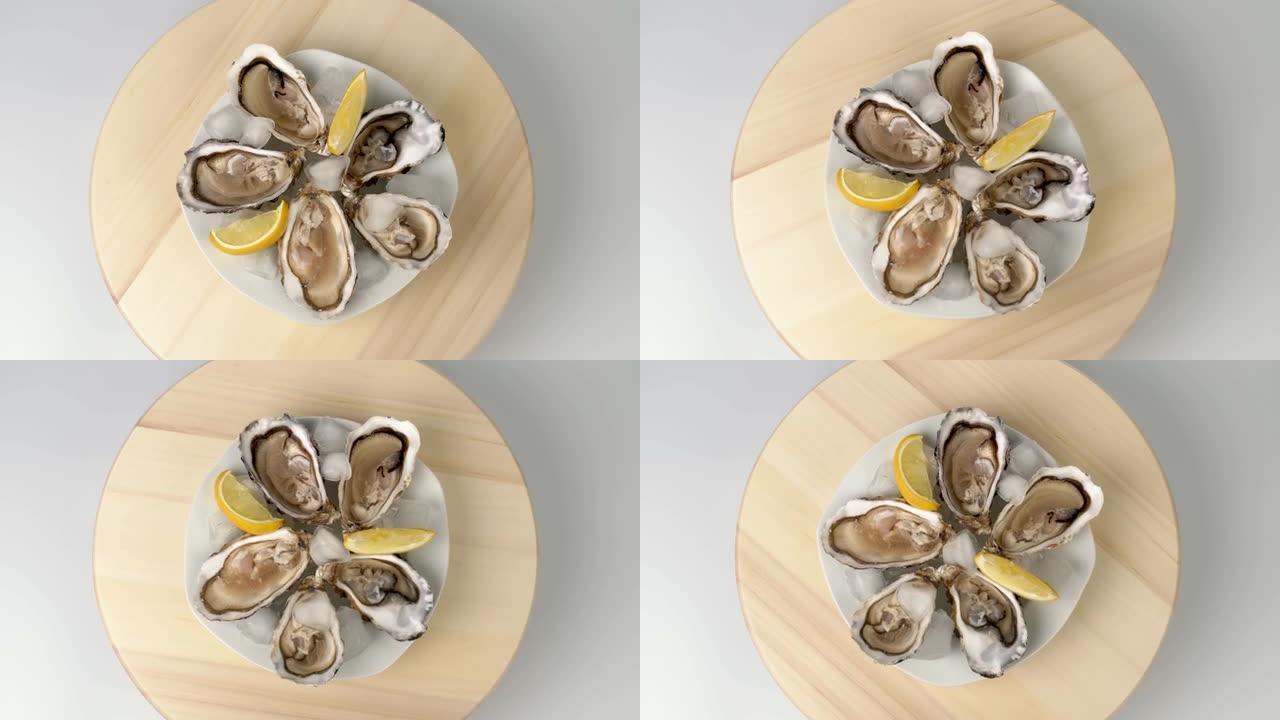 大厨在木托盘上烹制的牡蛎特写镜头，以大海为背景的柠檬为背景。海鲜美食。牡蛎农场种植的美味牡蛎。