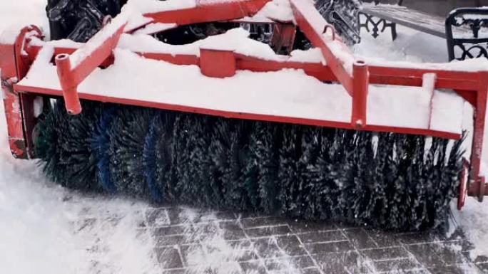 城市服务清扫积雪，一辆旋转刷子的小型拖拉机清除了城市公园的道路