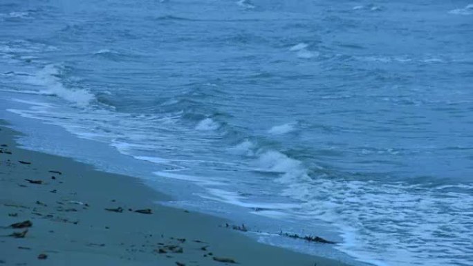 海浪冲刷沙滩的循环镜头。波涛汹涌的水面。