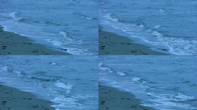 海浪冲刷沙滩的循环镜头。波涛汹涌的水面。