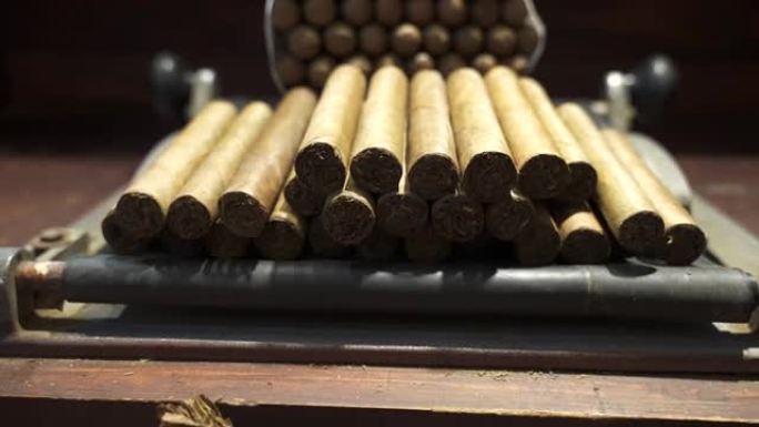 干燥的烟叶和手工卷制的优质古巴雪茄放在木制桌子上制作。世界上最好的雪茄