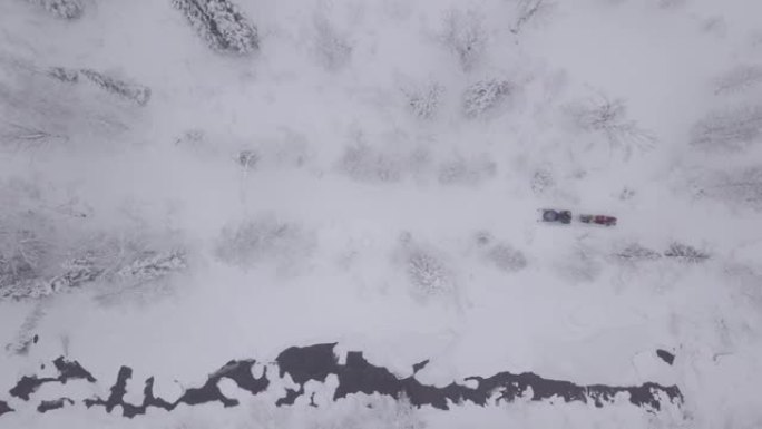 雪山路上人拉雪橇的雪地摩托鸟瞰图