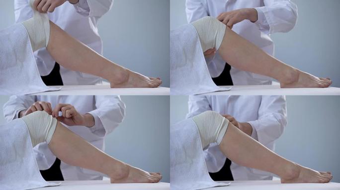 创伤专家在扭伤的患者腿部使用绷带，锻炼受伤