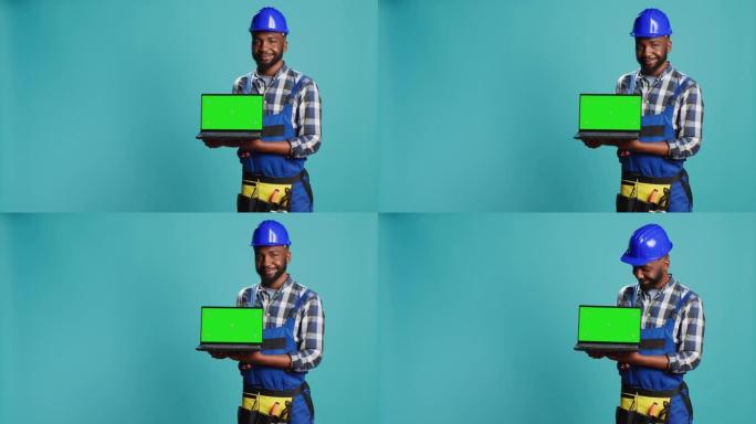 微笑的工匠展示带有绿色屏幕的笔记本电脑