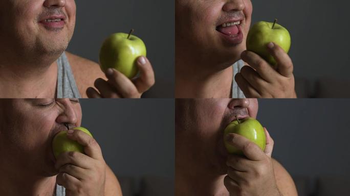 超重男子咬新鲜苹果，保持健康饮食减肥