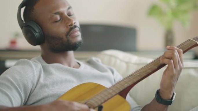非洲裔美国人拿着吉他，享受音乐。