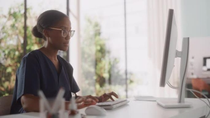 医院办公室一位美丽的黑人女性医疗保健专业人员在计算机上工作的肖像。诊所护士长正在在线指定处方，更新电