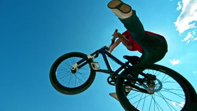 SLO MO Biker在阳光下空降时在DJ自行车上做了一个技巧