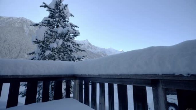 厚厚的积雪覆盖了山区的木制门廊栏杆