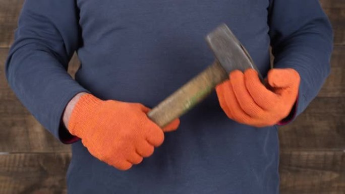 男子工人手握一把旧锤子，特写，维修工作的概念