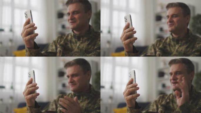 微笑的中年男性士兵用智能手机进行视频通话的特写